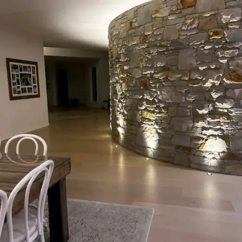 Curved sandstone feature wall lit inside a home