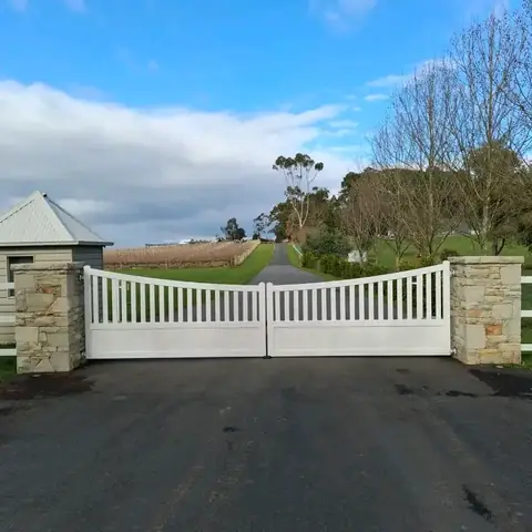 Sandstone entrance piers with white gates at Acacia Ridge Winery